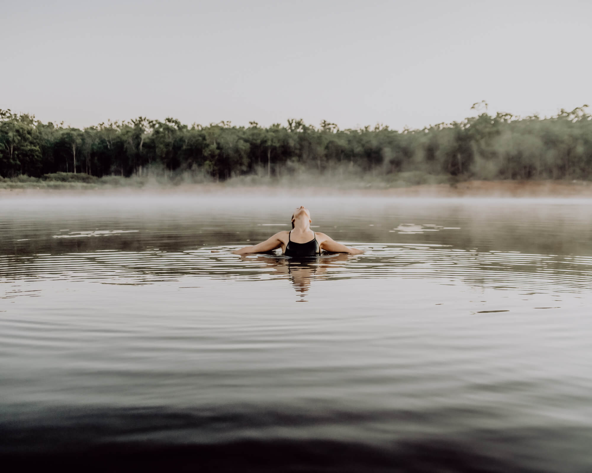 Eine Frau schwimmt in einem kühlen Bergsee.