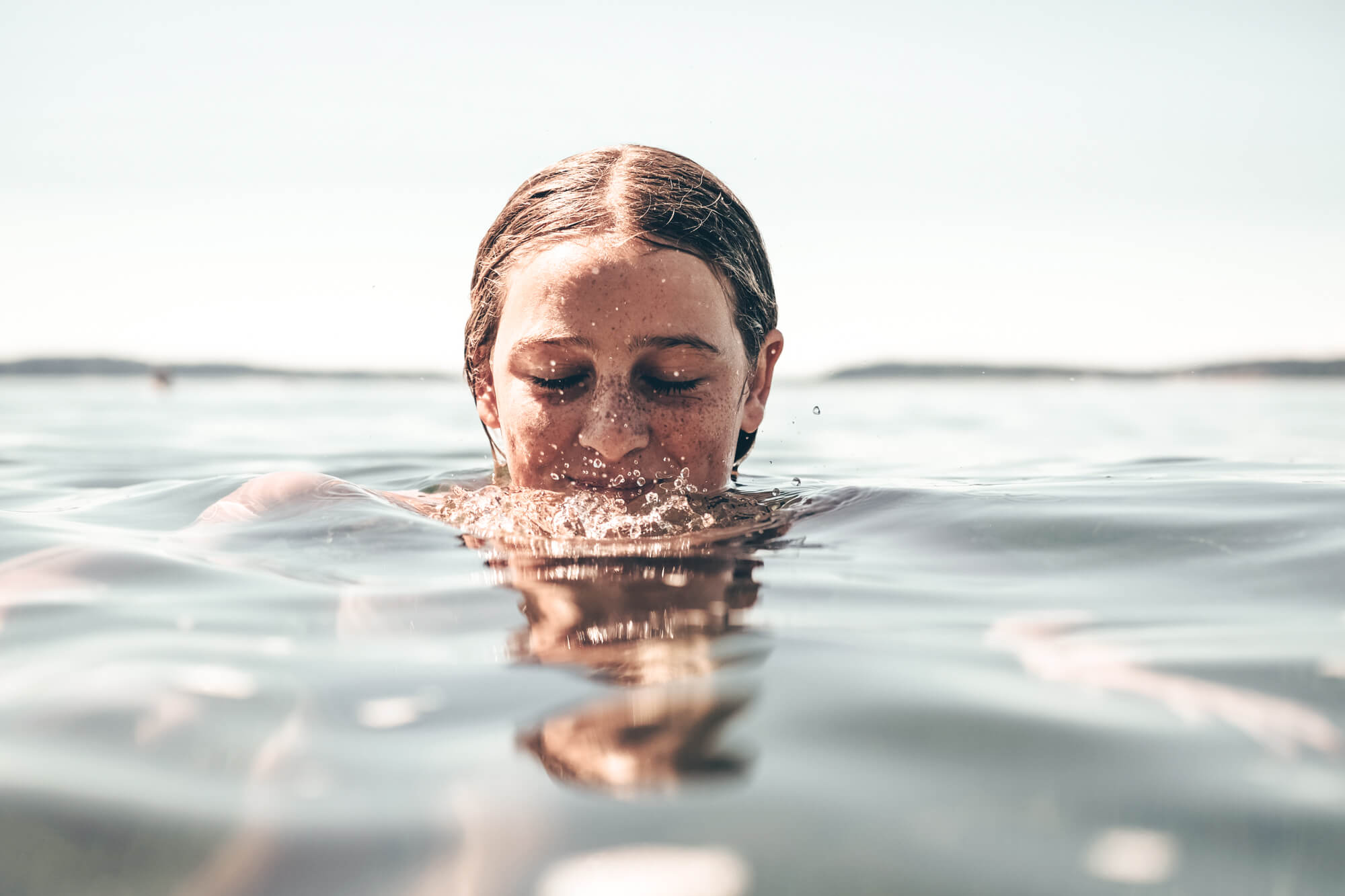Ein Mädchen ist bis zur Hälfte des Kopfes im Wasser.